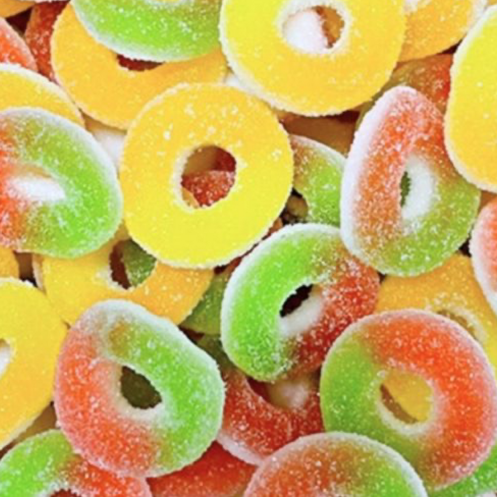 Colorful sour gummy candy rings in yellow, green, and orange.